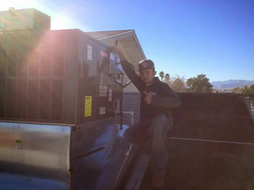 HVAC technician performing HVAC Inspection on a rooftop unit in Edinburg